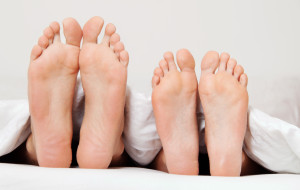 Dier Füße eines Paares im Bett. Trennung und Scheidung